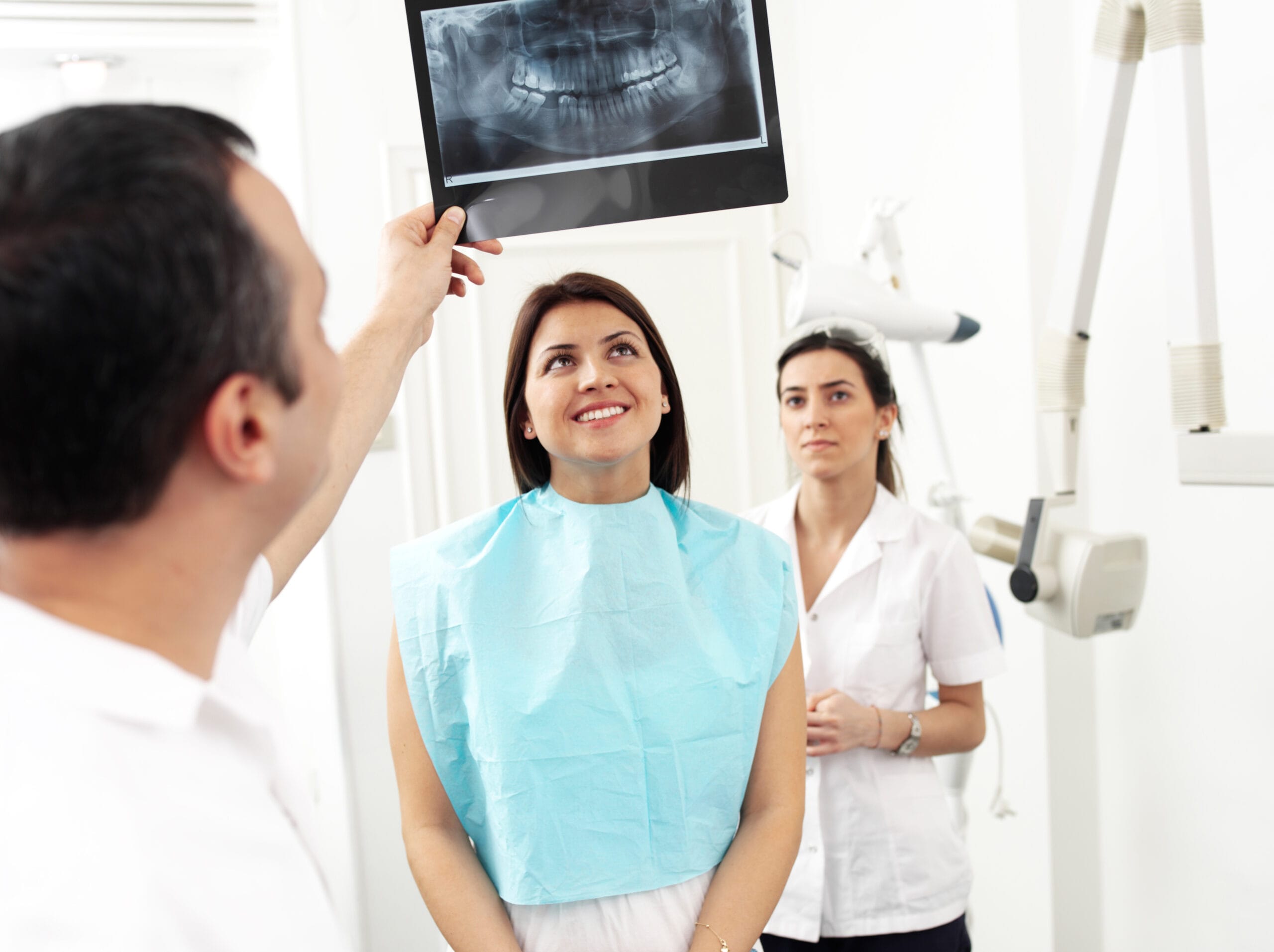 Young woman and dentist looking x-ray.